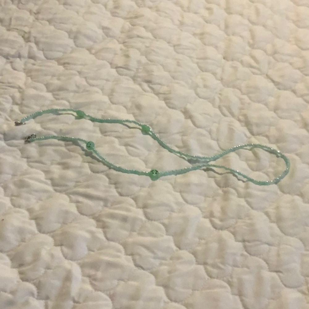 I am selling a green smiley necklace.